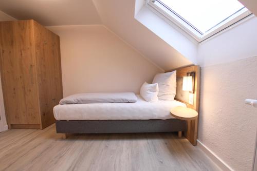 a bedroom with a bed and a skylight at 247 Selfcheckin Pferdemarkt in Leer