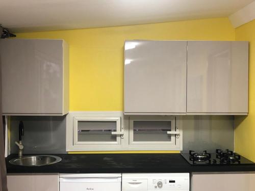 a kitchen with white cabinets and a sink at Be On The Beach in Sainte-Anne
