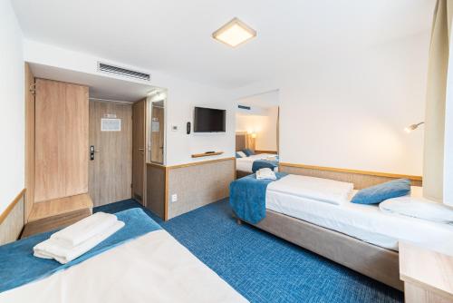 a hotel room with two beds and a tv at Botel Racek in Prague