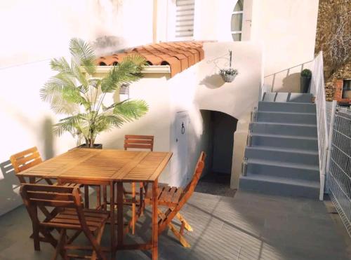 einen Tisch und Stühle auf einem Balkon mit Treppen in der Unterkunft Une pause au vert'gnate in Le Breuil-sur-Couze
