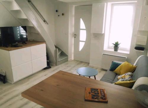 ein Wohnzimmer mit einem Sofa und einem Tisch in der Unterkunft Une pause au vert'gnate in Le Breuil-sur-Couze