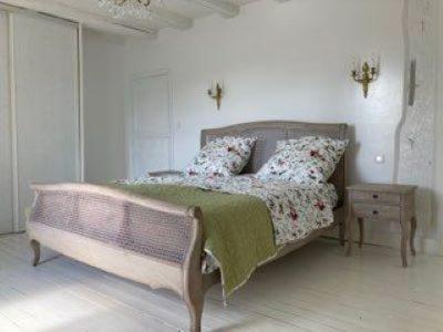 a bedroom with a bed and a night stand and a table at Villa spacieuse très élégante idéale à la détente in Lamargelle