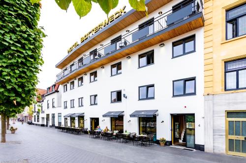 a white building with tables and chairs on a street at Hotel Botterweck in Valkenburg