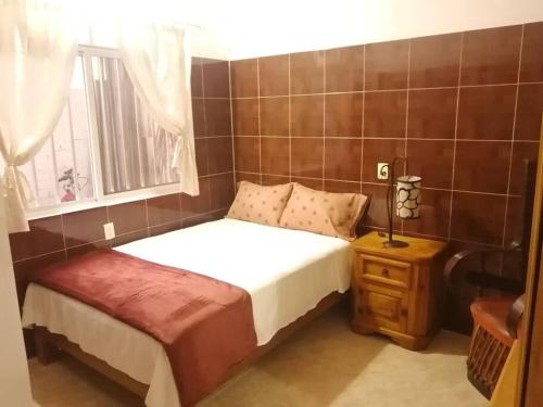 a small bedroom with a bed and a window at Casa Maribel Lugar para descansar en ixtapa in Ixtapa