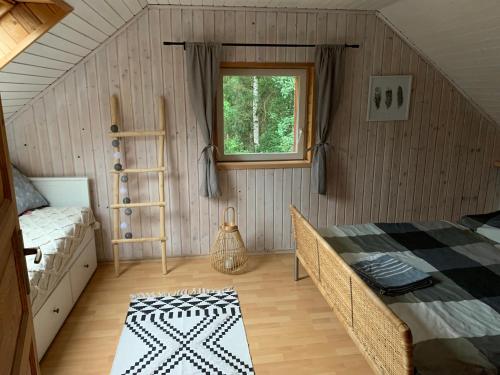 1 dormitorio con cama y ventana en Hygge chaloupka v horách, en Český Jiřetín