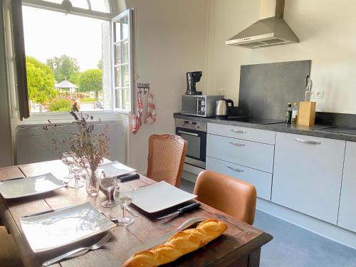 - une cuisine avec une table et un ordinateur portable dans l'établissement Coeur de Sologne, la Loire et les châteaux., à Dhuizon