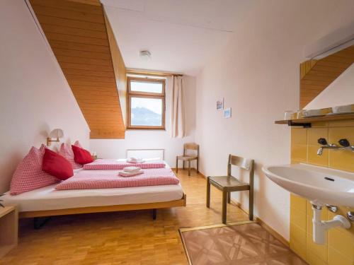 1 dormitorio con 1 cama y lavamanos. en Berggasthaus Tannalp en Frutt