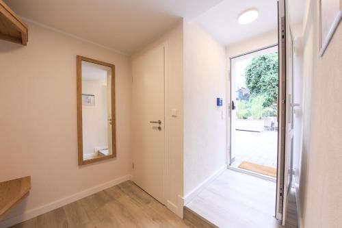 a hallway with a door and a mirror at 247 Selfcheckin Pferdemarkt in Leer