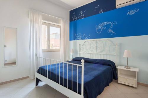 um quarto com uma cama com uma parede azul em Il Fascino della Sirena - Sea House em Giardini Naxos