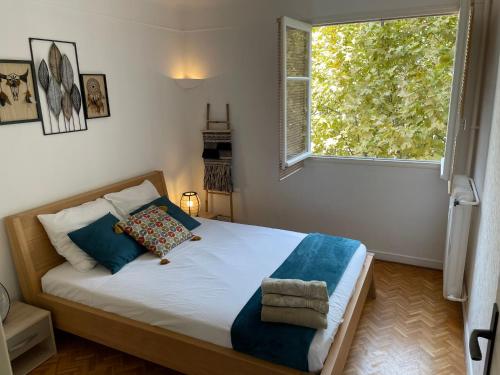 une chambre avec un lit avec une grande fenêtre dans l'établissement Terrasse plein sud, deux chambres doubles, à Antibes