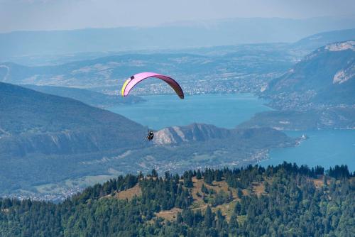 a person is flying a parachute over a lake at Maison Lennox in Mâcot La Plagne