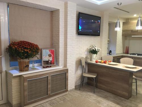 a kitchen with a counter and a tv on a wall at Studio Luxe on Victory Street in the city center in Vinnytsya