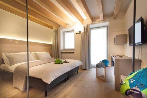 ein Schlafzimmer mit einem großen Bett und einem Spiegel in der Unterkunft Casa Alla Lega in Arco