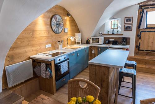 a kitchen with blue cabinets and a clock on the wall at Maison Lennox in Mâcot La Plagne