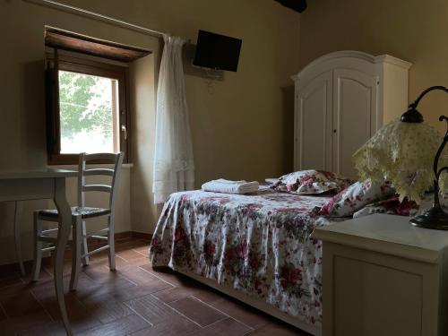 a bedroom with a bed and a desk and a window at Le Farine Del Maestro in Barete