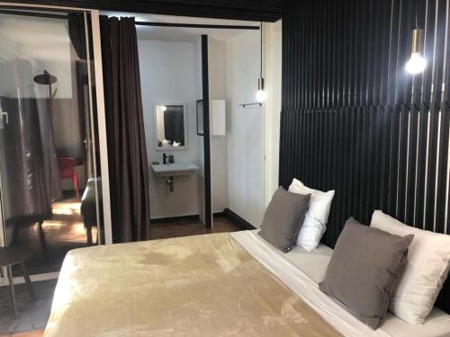 a bedroom with a large bed and a bathroom at Be On The Beach in Sainte-Anne
