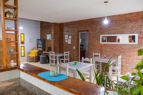 ein Zimmer mit Tischen und Stühlen und einer Ziegelwand in der Unterkunft Casa Patagonica in Puerto Madryn