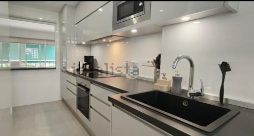 a kitchen with a sink and a counter top at Sunnybeach Apartment mit direktem Strandzugang in Denia