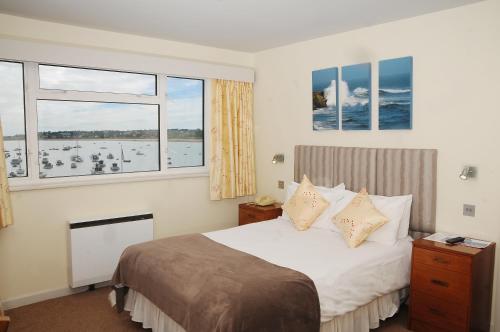 a bedroom with a bed and two windows at Dolphin Hotel in Gorey