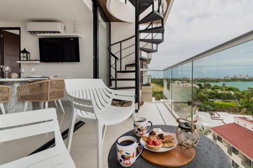 a room with a table with a plate of food on a balcony at ☆Brand new 2BR PH by CASA PARAISO☆ in Cancún