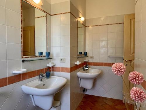 a bathroom with two sinks and a mirror at Sera & Mattino Appartamenti by SolturElba in Capoliveri
