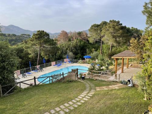 a large swimming pool in a yard with a hill at Sera & Mattino Appartamenti by SolturElba in Capoliveri