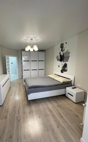 1 dormitorio con 1 cama grande y suelo de madera en VIP Апартаменти подобово, en Lutsk