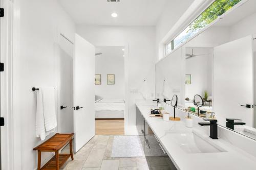 a bathroom with white walls and a large sink and a window at Dallas Luxury Modern House By Dallas Love Airport in Dallas