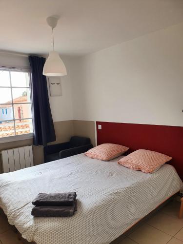 une chambre avec un lit avec deux oreillers dessus dans l'établissement Maison le Havre de la Gachère, 2 chambres, 2 salles d'eau, parking privé et jardin, à Brem-sur-Mer