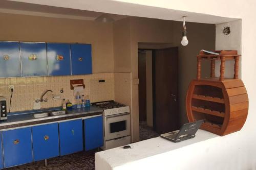 a kitchen with blue cabinets and a laptop on a counter at Casa de cuatro dormitorios, ideal dos familias in San Fernando del Valle de Catamarca