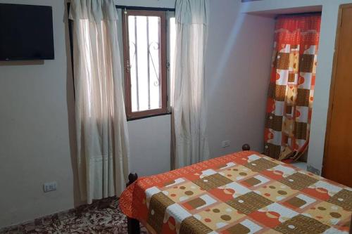 a bedroom with a bed and a window at Casa de cuatro dormitorios, ideal dos familias in San Fernando del Valle de Catamarca
