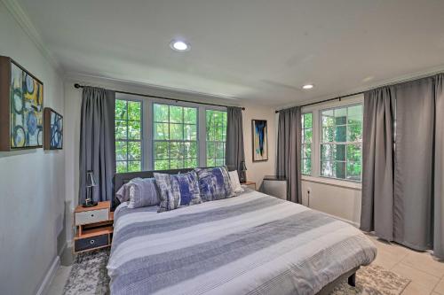 a bedroom with a large bed and large windows at Chic House with Private Dock on Lake Hartwell! in Townville