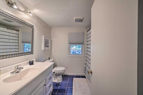 a bathroom with a sink and a toilet and a mirror at Chic House with Private Dock on Lake Hartwell! in Townville