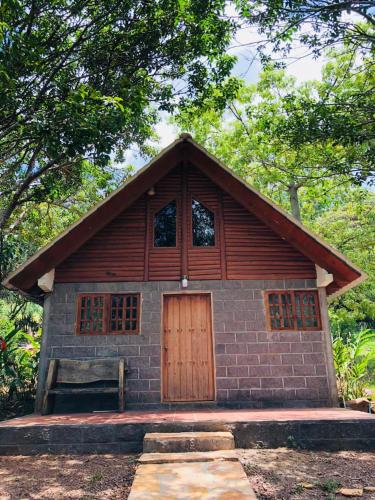 a small building with a wooden door and a bench at Finca Esperanza in Arambala