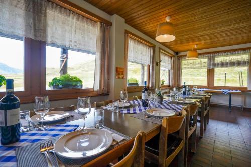 uma sala de jantar com uma longa mesa com copos de vinho em Berggasthaus Tannalp em Frutt