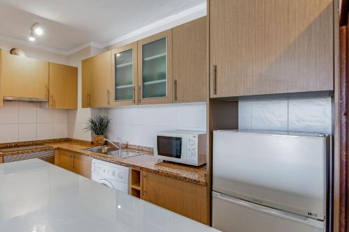 a kitchen with a refrigerator and a microwave at Bright 1BDR Apartment W/Balcony & Pool by LovelyStay in Silves