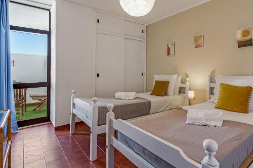 Cette chambre dispose de 2 lits et d'un balcon. dans l'établissement Bright 1BDR Apartment W/Balcony & Pool by LovelyStay, à Silves