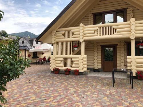 a house with a brick patio in front of it at Smerekova Hata in Mizhhirya