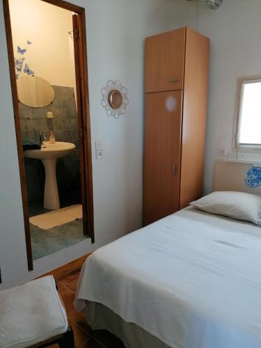 une chambre avec un lit, un lavabo et un miroir dans l'établissement Les romarins, à Saint-Jean-de-Minervois