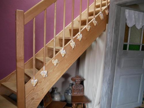 a wooden staircase with white flowers on it at Chambres d'hôtes "La Bouill'hôte" in Langensoultzbach
