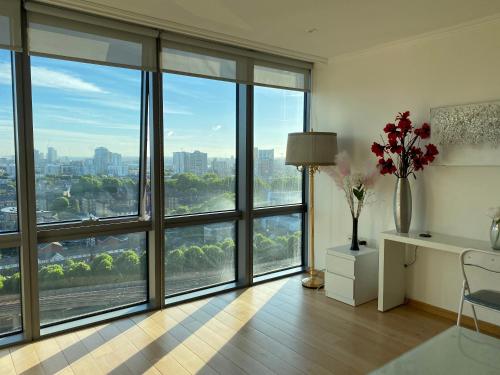 um quarto com grandes janelas com vista para a cidade em 1 Bed- Dedicated Workspace, Coffee maker 4KTV em Londres