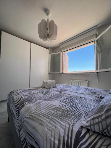 - une chambre avec un lit, un ventilateur de plafond et une fenêtre dans l'établissement Preciosa vivienda con gran terraza muy luminoso, à Grenade