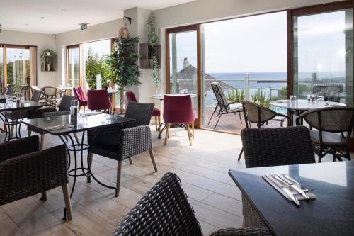 a restaurant with tables and chairs and a balcony at Hotel Penzance in Penzance