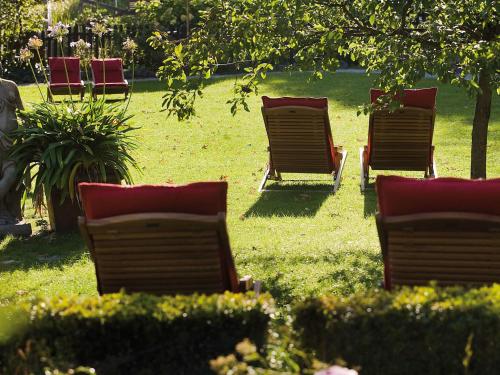 a group of chairs sitting in the grass at Landhaus Benediktenhof in Bad Tölz