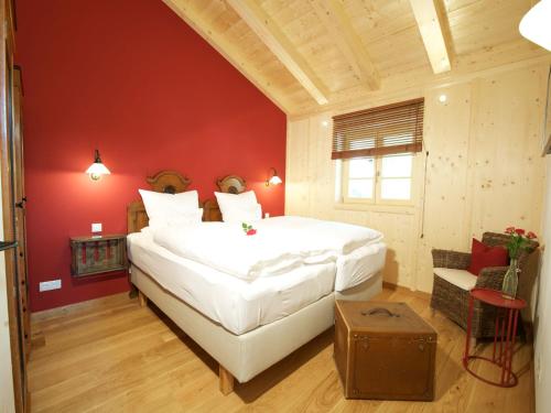 a bedroom with a large white bed and red walls at Landhaus Benediktenhof in Bad Tölz