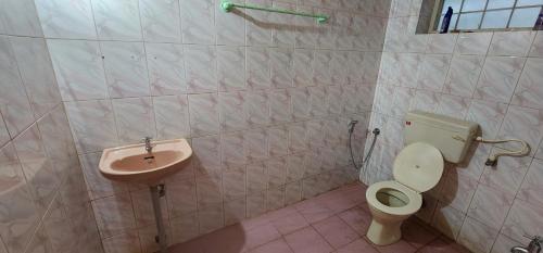 a bathroom with a toilet and a sink at JJ's White House in Trichūr