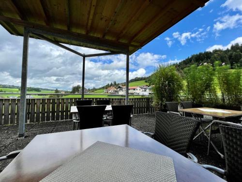 a patio with a white table and chairs and a fence at Pension & Gasthof zur Taube in Sulzberg
