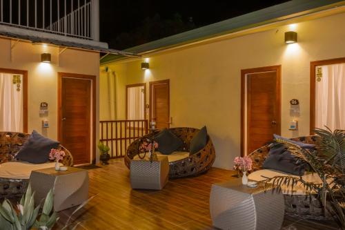 a living room with couches and tables on a wooden floor at Green Leaf Guest House - Omadhoo in Omadhoo