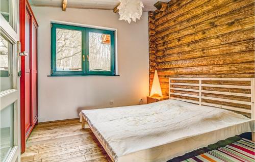 ノベ・バルプノにあるAmazing Apartment In Nowe Warpno With 1 Bedrooms And Wifiの木製の壁のベッドルーム1室(ベッド1台付)