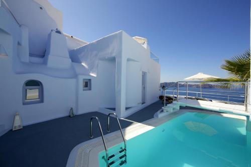 a villa with a swimming pool next to a house at Ikastikies Suites in Firostefani